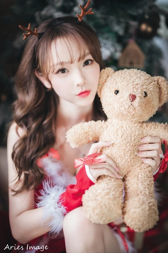 一位年轻女子抱着泰迪熊摆姿势