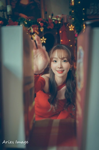 一位穿着红色的年轻女子正在照相 手放在冰箱上