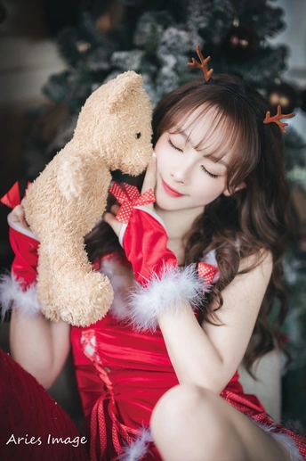 一位穿着红色连衣裙的年轻女子抱着一个填充玩具