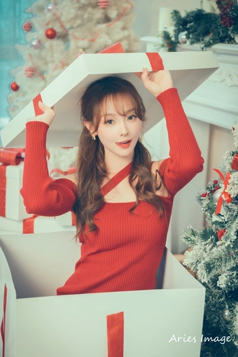 一位戴着红色毛衣的年轻女子举着一个盒子在头上