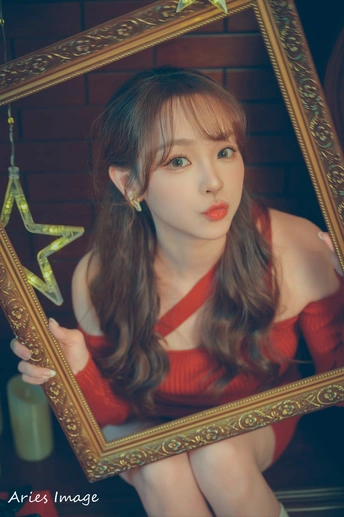 一位穿着红裙子的年轻女子手持镜子摆姿势拍照