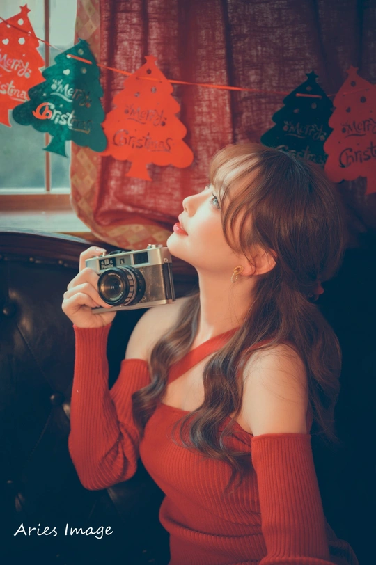 一位年轻女子手持相机拍照