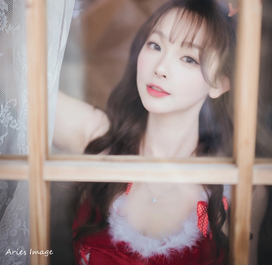 一位穿着红裙子的年轻女子正在窗户旁向外看