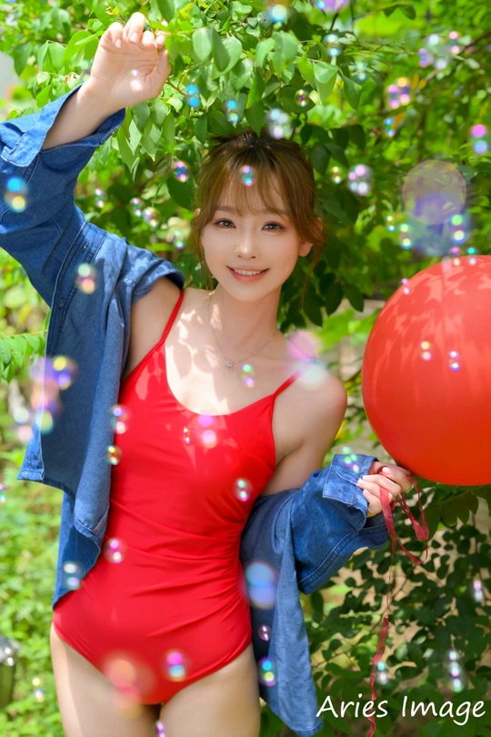 一位年轻女子拿着一个红气球吹泡泡