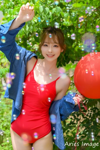 一位年轻女子拿着一个红气球吹泡泡