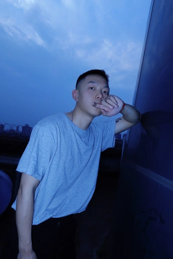 一个年轻人靠墙站着 手放在脸上