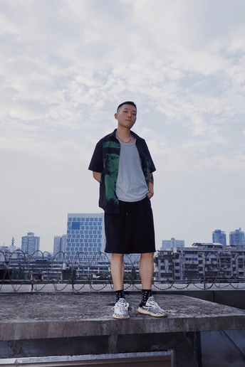 一个年轻人站在屋顶的窗台上俯瞰着一座城市