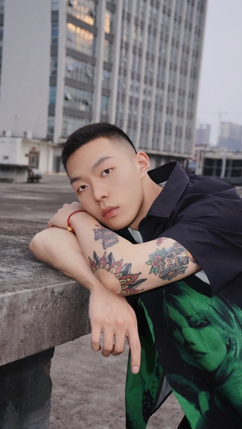 一个手臂上有纹身的年轻人在长椅上摆姿势