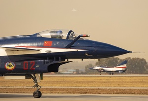 一架蓝色和红色的战斗机从跑道上起飞