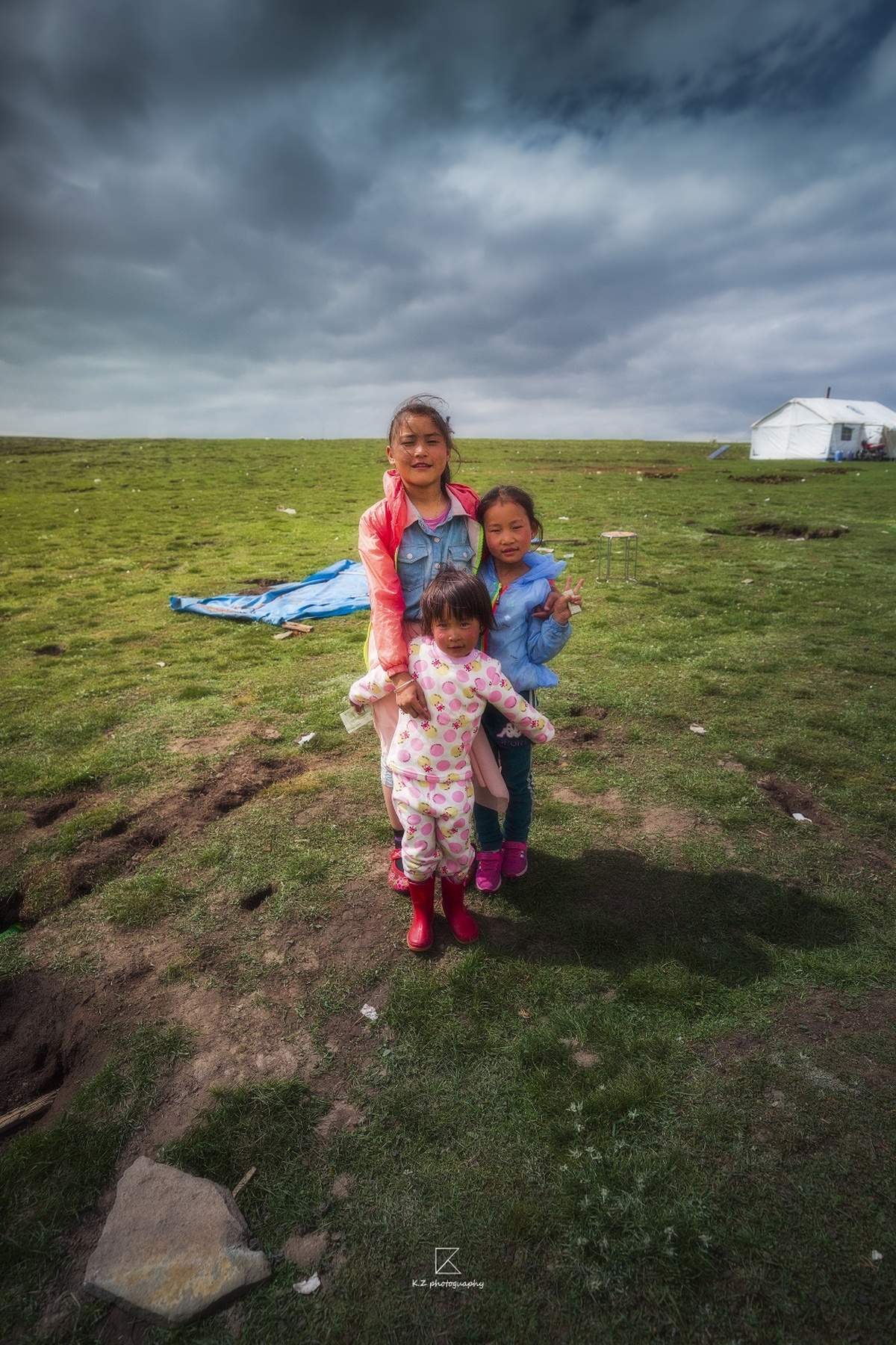 两个小女孩站在一个田野中 背景是天空