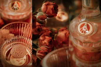 一张玫瑰花点缀的桌子 上面放着蜡烛和玻璃杯。