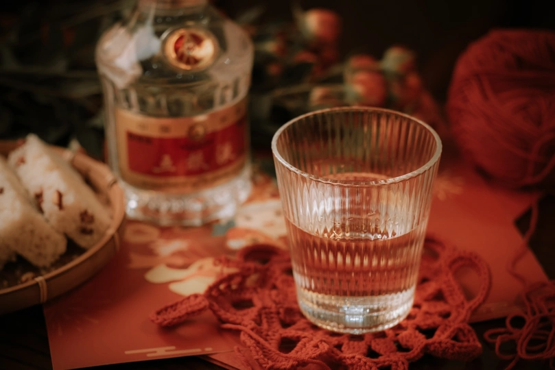 一只玻璃杯放在桌子旁边的一瓶酒精上