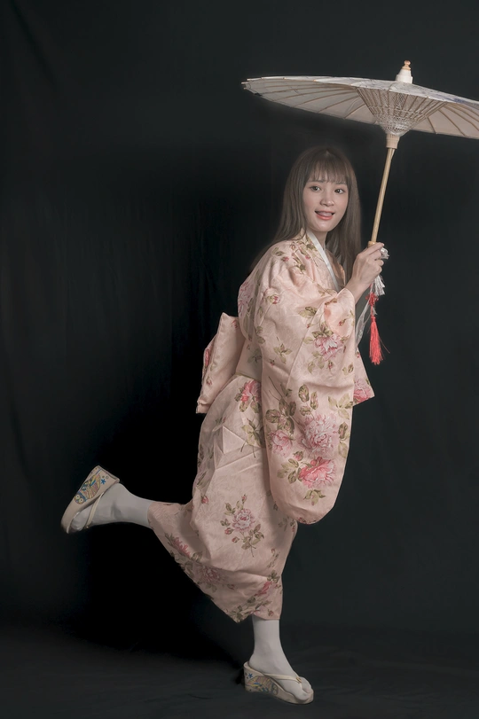 一个穿着和服、打着白色雨伞的年轻女子