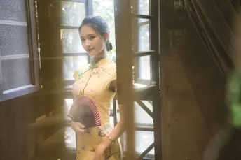 一位穿着黄色连衣裙的女人 holding a door and looking out a wind