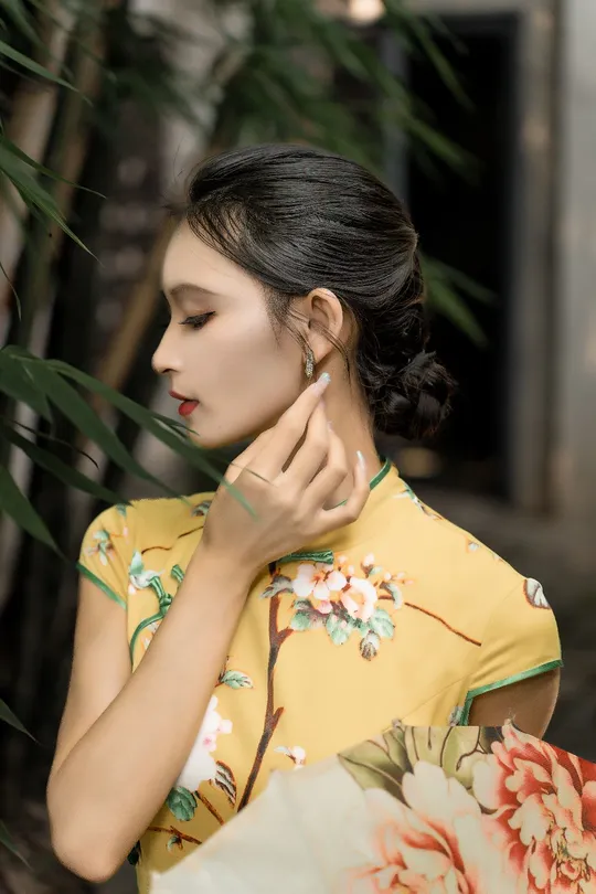 一位穿着黄色连衣裙和花式和服的年轻女子