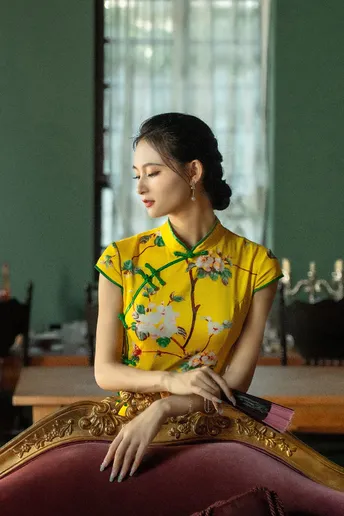 一位穿着黄衬衫的女性坐在化妆台上