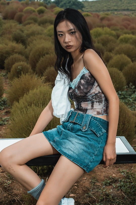 一个年轻女子坐在白色长凳上 双腿交叉