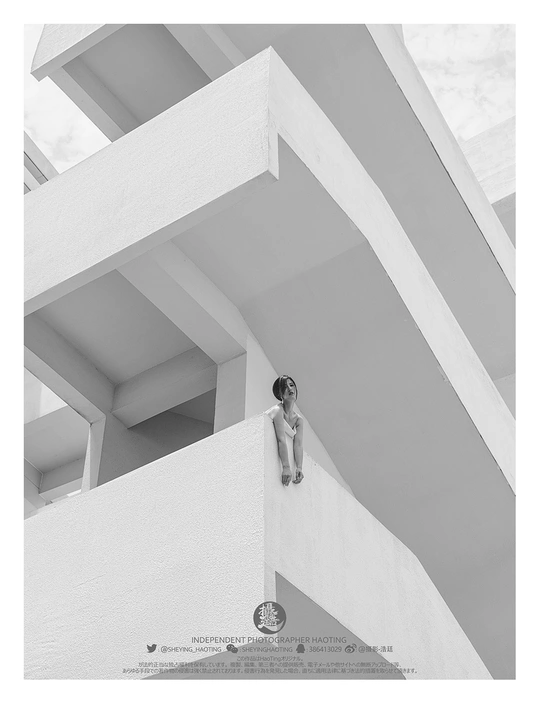 一个女孩坐在白色建筑的边缘 一个男孩站在建筑的边缘。