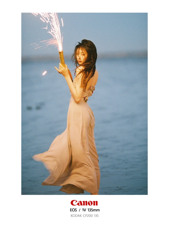 一个穿着连衣裙的年轻女子站在水中 手里拿着一个闪闪发光的东西