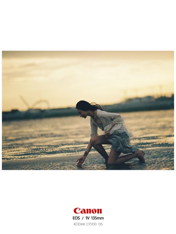 一个年轻女子跪在水边的海滩上