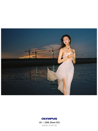 一个穿着白色连衣裙的女人站在水体附近