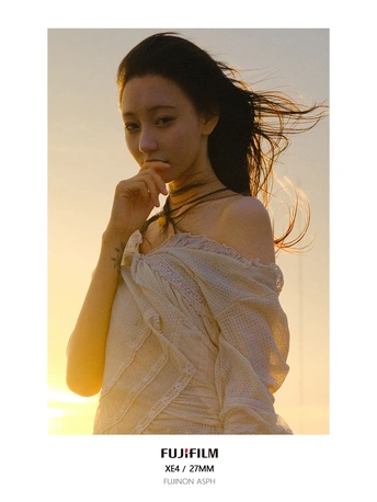 日落时分 一位身穿白色连衣裙的年轻女子在风中摆姿势