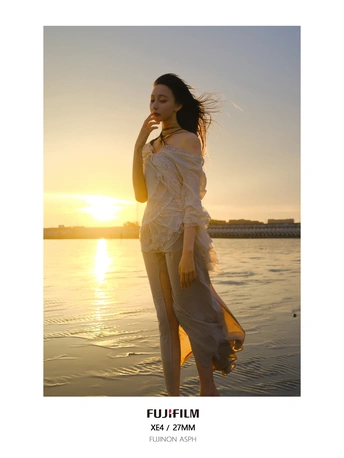 日落时 一位身穿白色连衣裙的年轻美女在水体前摆姿势