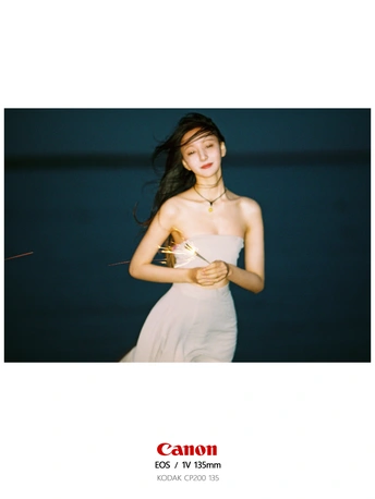 一个穿着白色连衣裙的年轻女子站在黑暗中