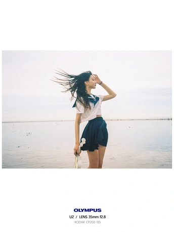 一个女人站在海边的海滩上 头发悬空