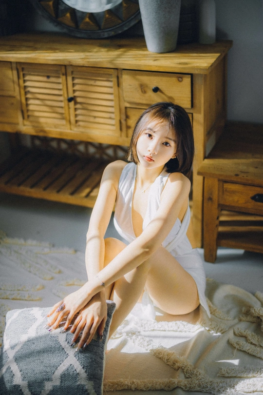 一个年轻女子坐在地板上的一块白毛巾上