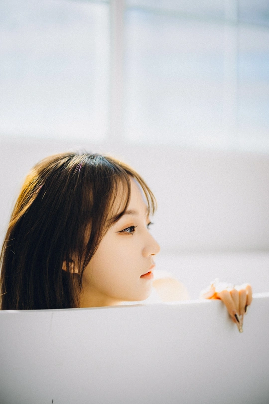 一个年轻女子坐在浴缸里洗澡