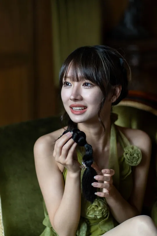 一个穿着绿色连衣裙的年轻女子坐在绿色椅子上