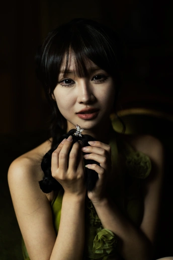 一位穿着绿色连衣裙的年轻女子坐在椅子上 双手抱在胸前