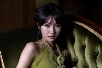 一个穿着绿色连衣裙的年轻女子坐在沙发上