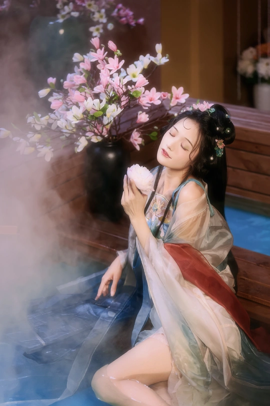 一位年轻女士坐在地上 手里拿着一束花。