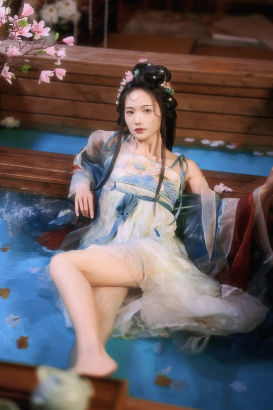 一位穿着蓝色裙子的女人坐在水边的长凳上的一幅画