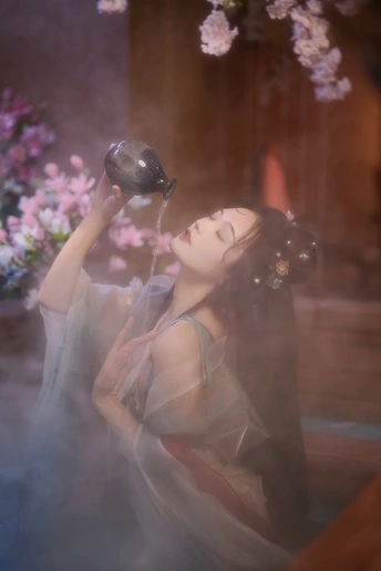 一位女士拿着一杯红酒喝着水