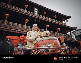 一个人在楼前敲鼓