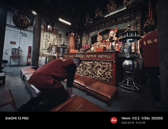 一个坐在红色墙壁房间里的长凳上的男人