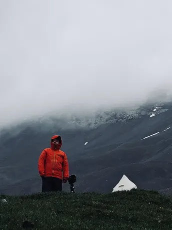 一个穿红夹克的男人站在山顶