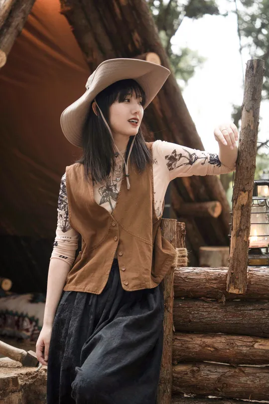 一位戴帽子的女人站在茅屋里