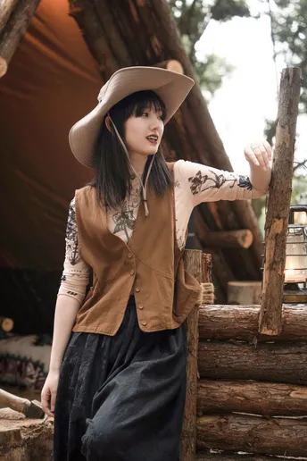 一位戴帽子的女人站在茅屋里