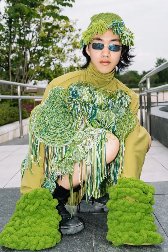 一位穿着绿色服装的模特在时装秀上。