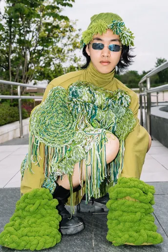 一位穿着绿色服装的模特在时装秀上。