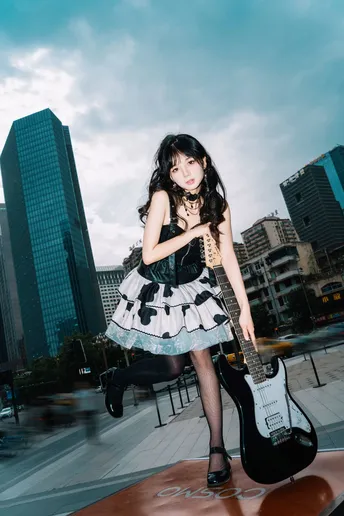 站在屋顶上的穿着连衣裙的女孩抱着吉他