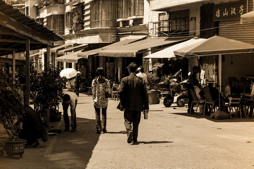 一张黑白照片 人们正在走下街道。