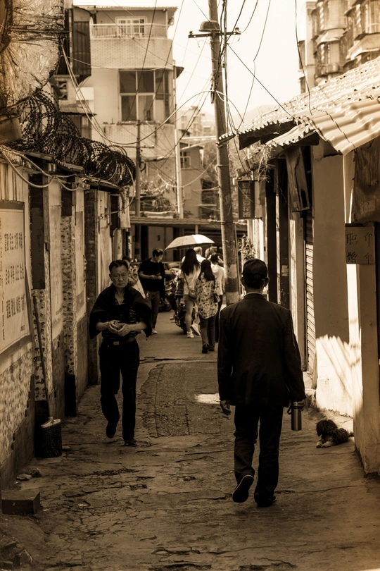 城市中破败建筑的狭窄巷道中行走的黑白色人