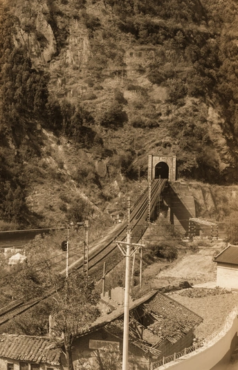 一张黑白照片 火车在靠近小河的轨道上行驶。