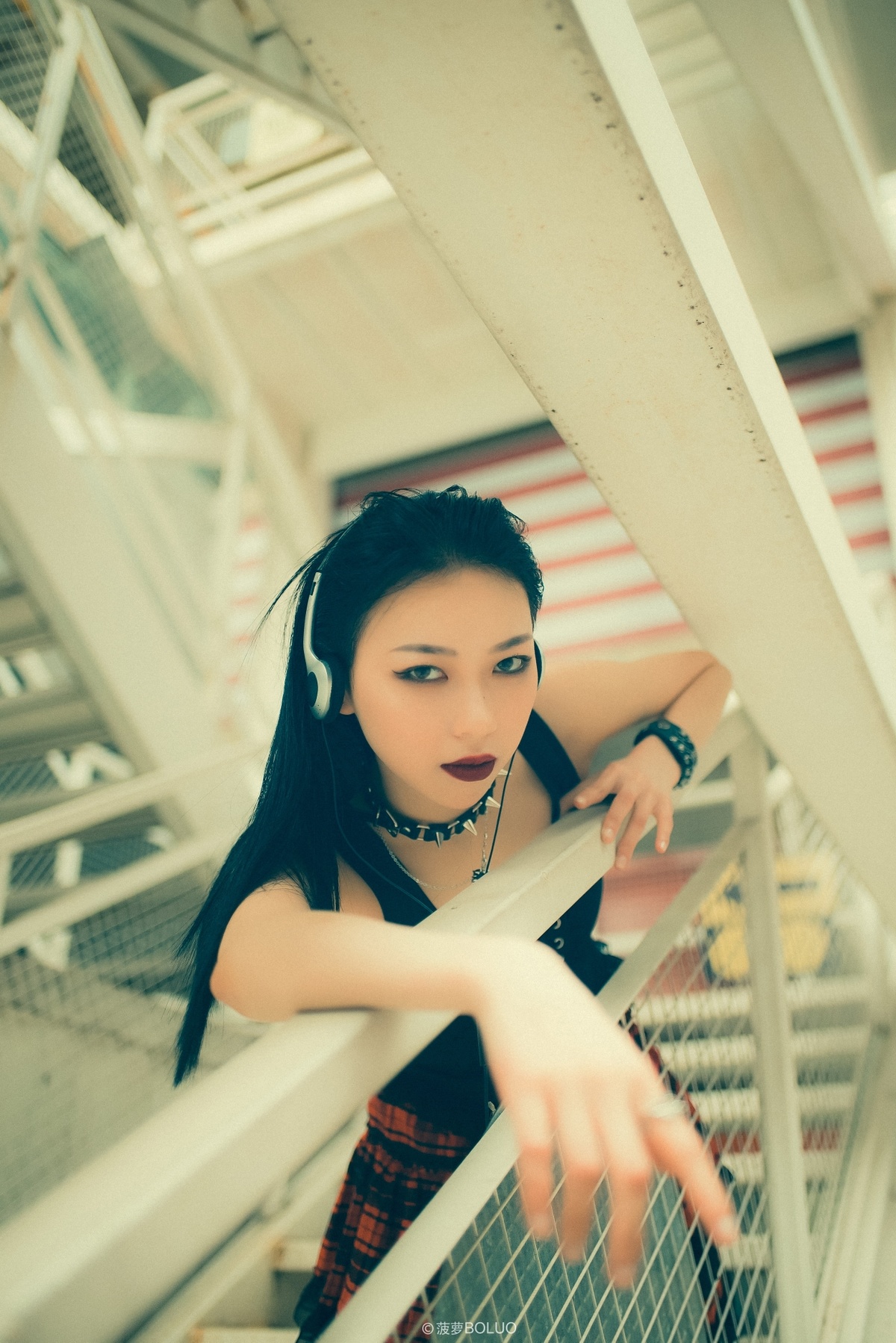 一个戴耳机站在楼梯上的年轻女子