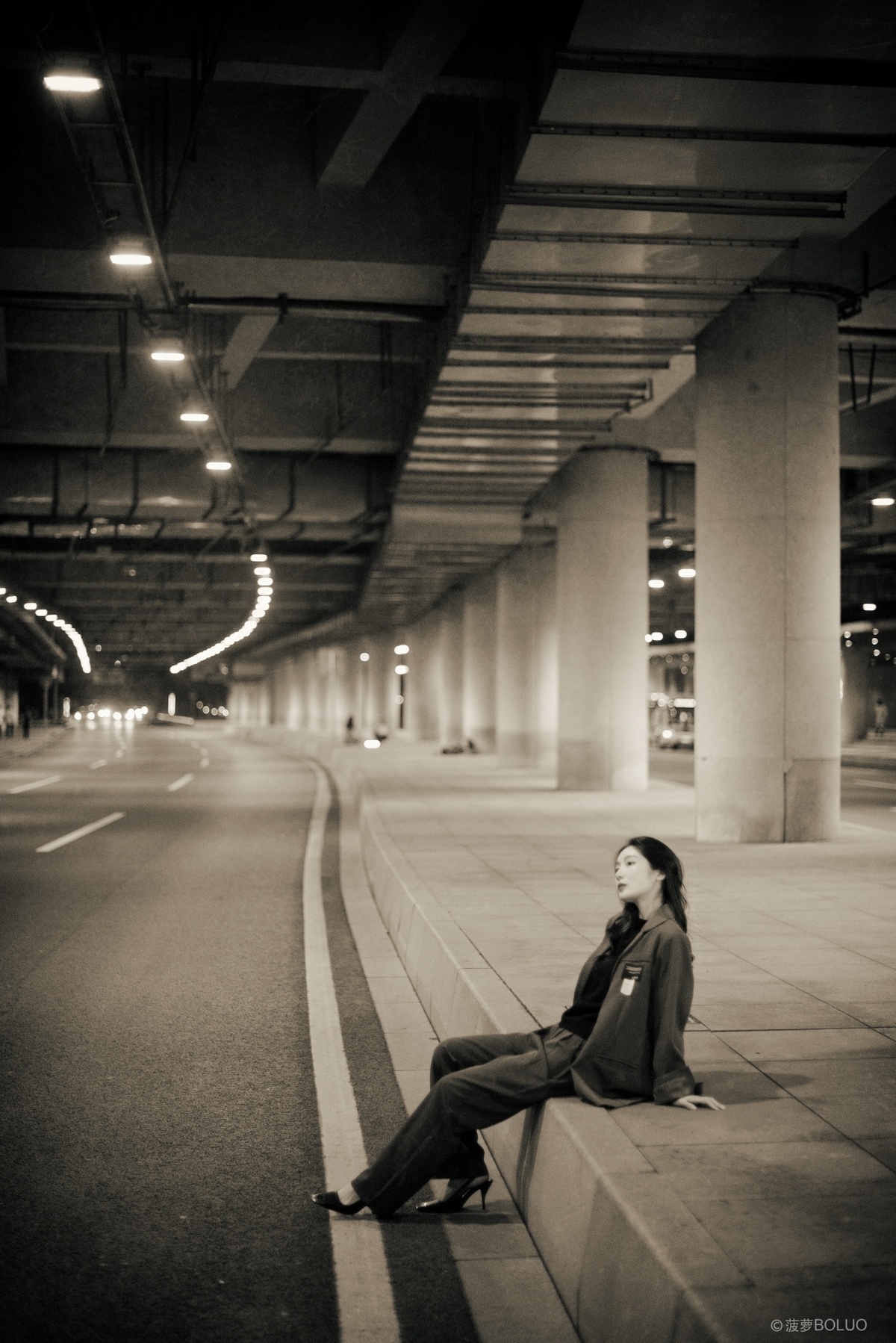 一个年轻女子坐在夜晚空荡的地铁长椅上